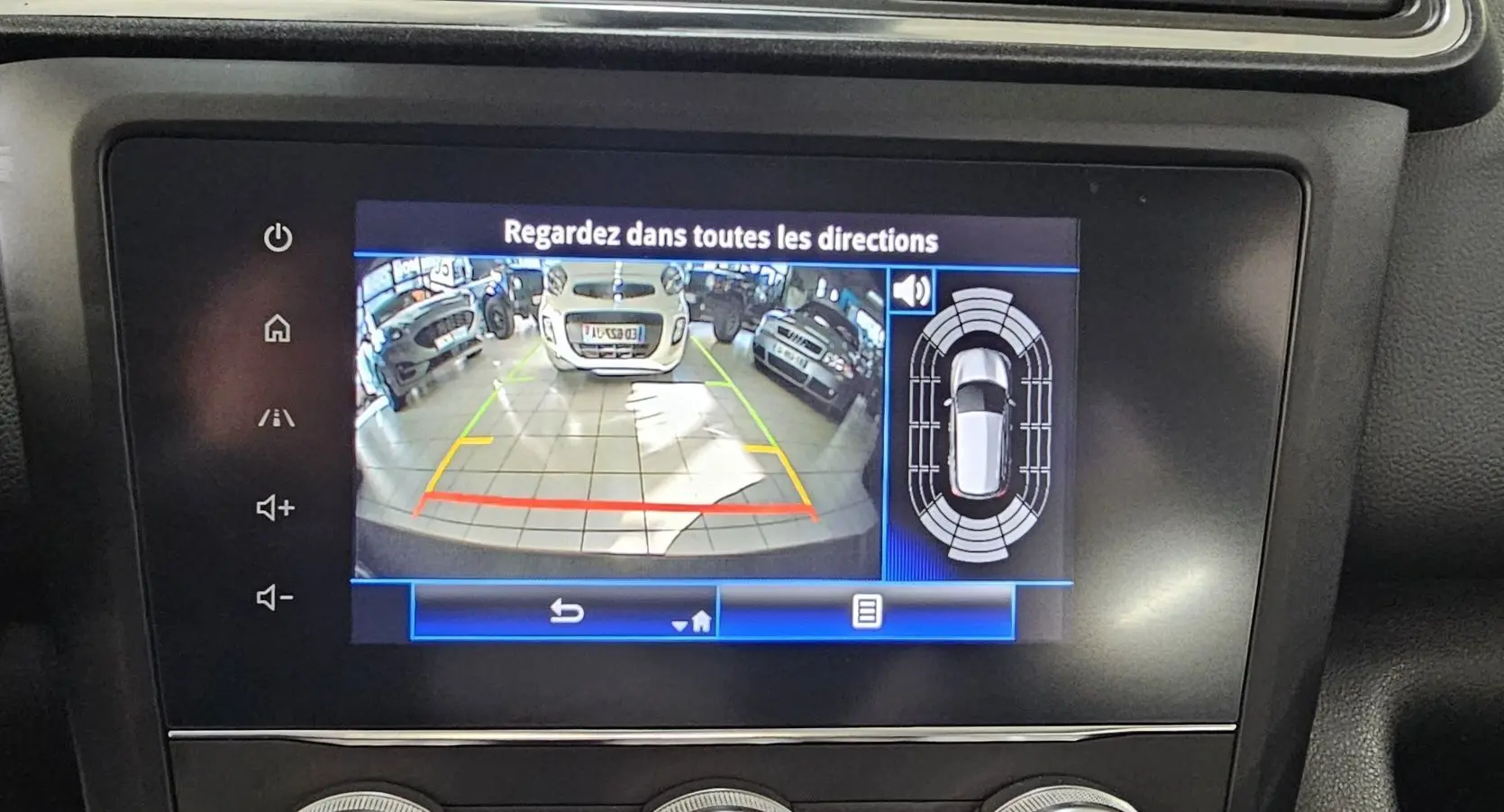 Écran de caméra de recul du Renault Kadjar noir, montrant l’arrière et les véhicules garés en intérieur.
