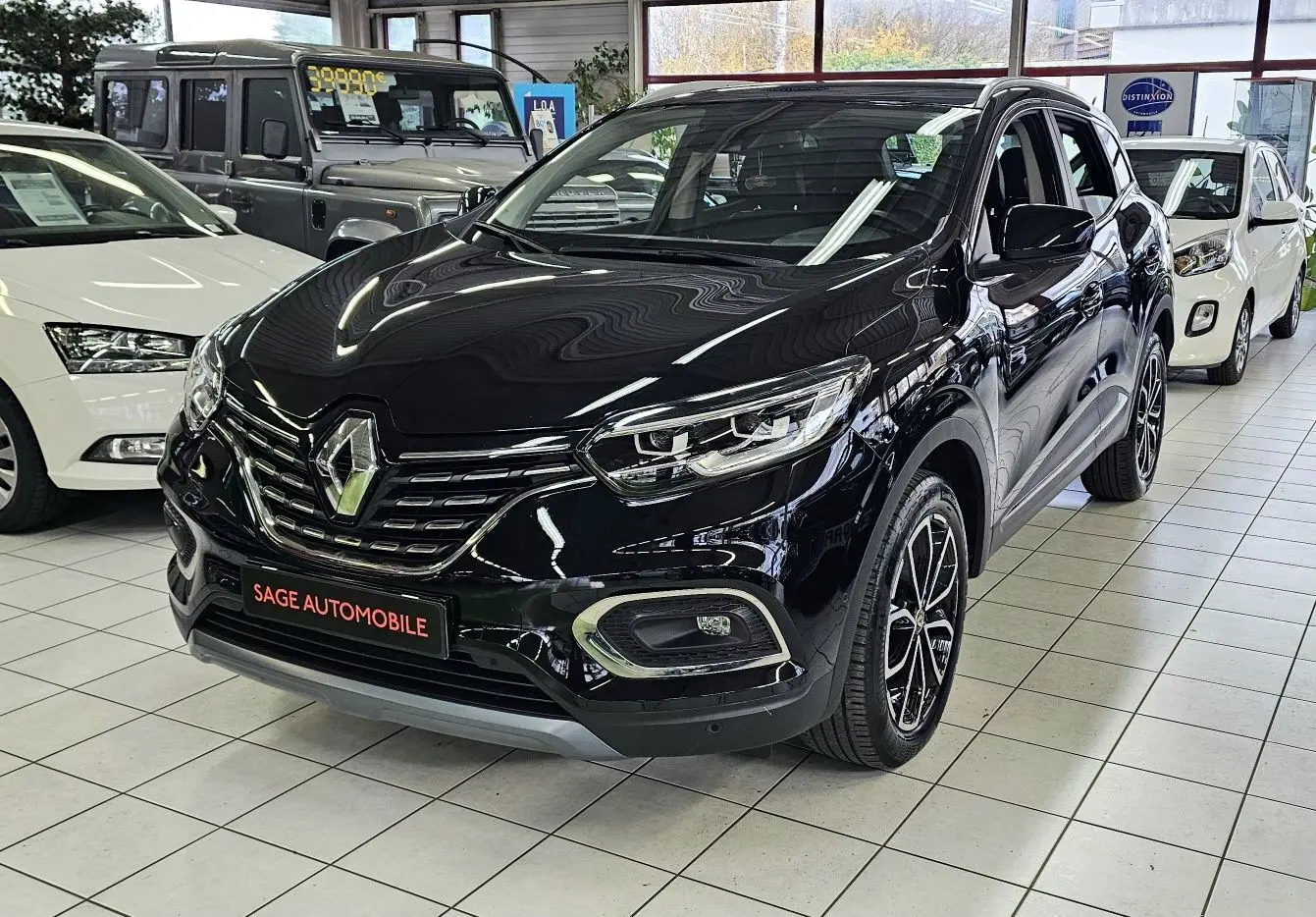 Renault Kadjar noire vue en 3/4 avant droit, avec jantes bi-ton et calandre chromée brillante.