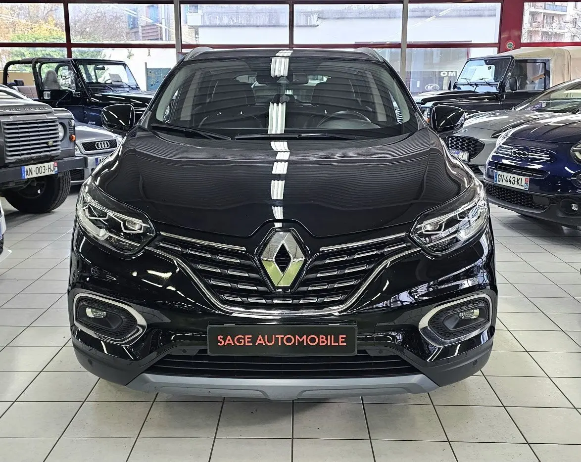 Vue frontale d'un Renault Kadjar noir 2021 en showroom, avec calandre chromée et phares LED distinctifs.