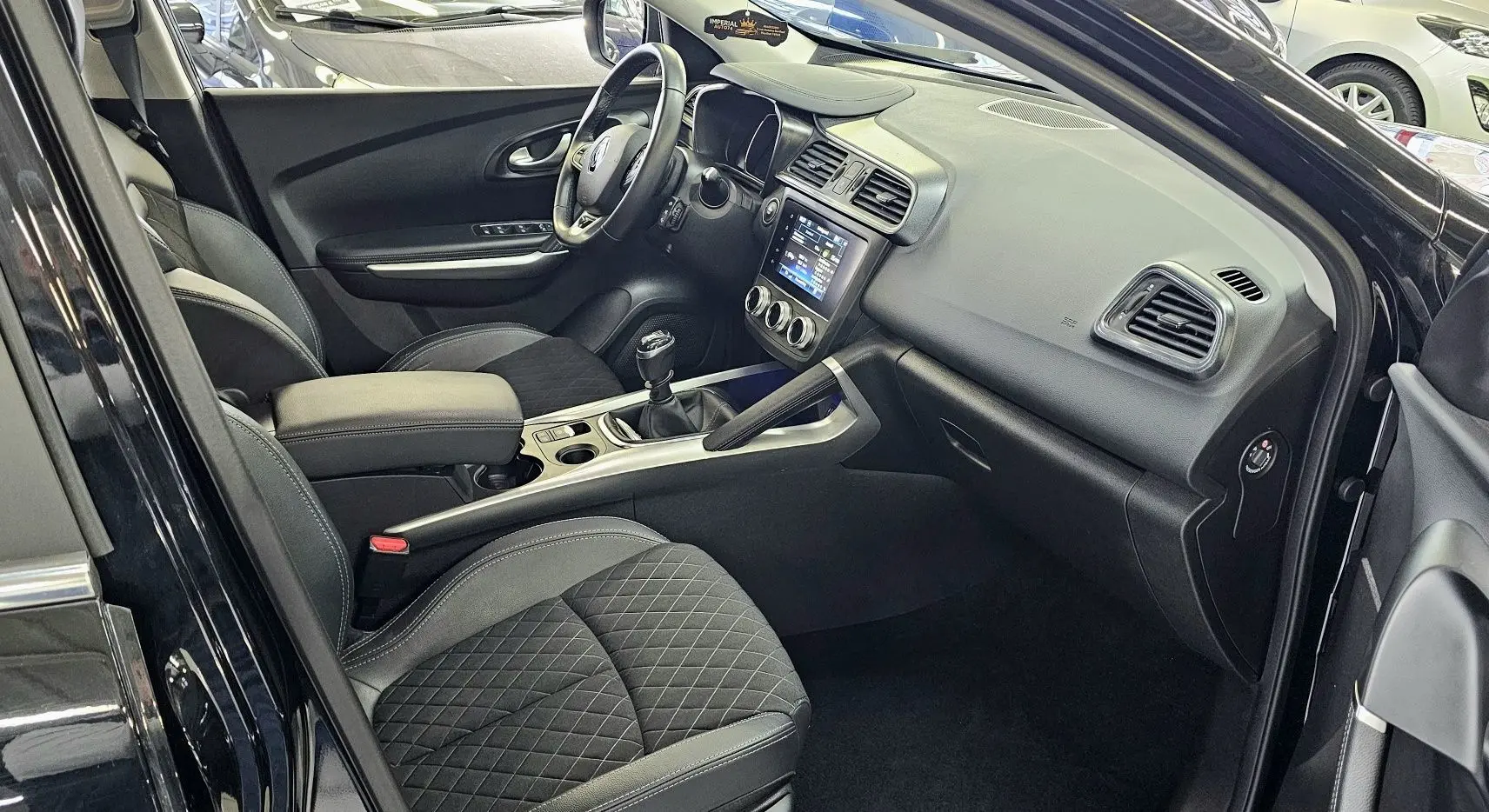Intérieur noir du Renault Kadjar 2021 vu côté conducteur, avec sièges en cuir et tableau de bord moderne.