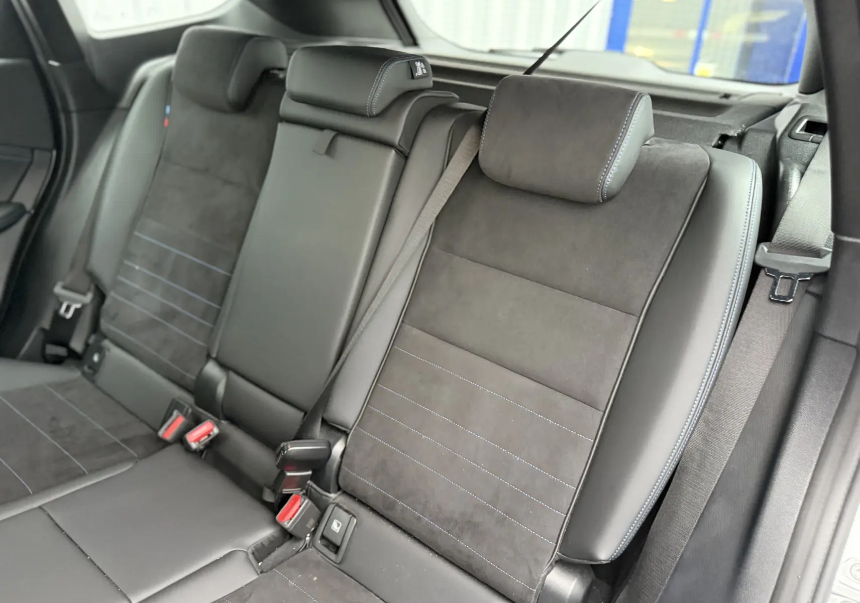 Vue caméra 360° du BMW X1 blanc mineral en stationnement, affichage écran intérieur avec guidage de trajectoire.