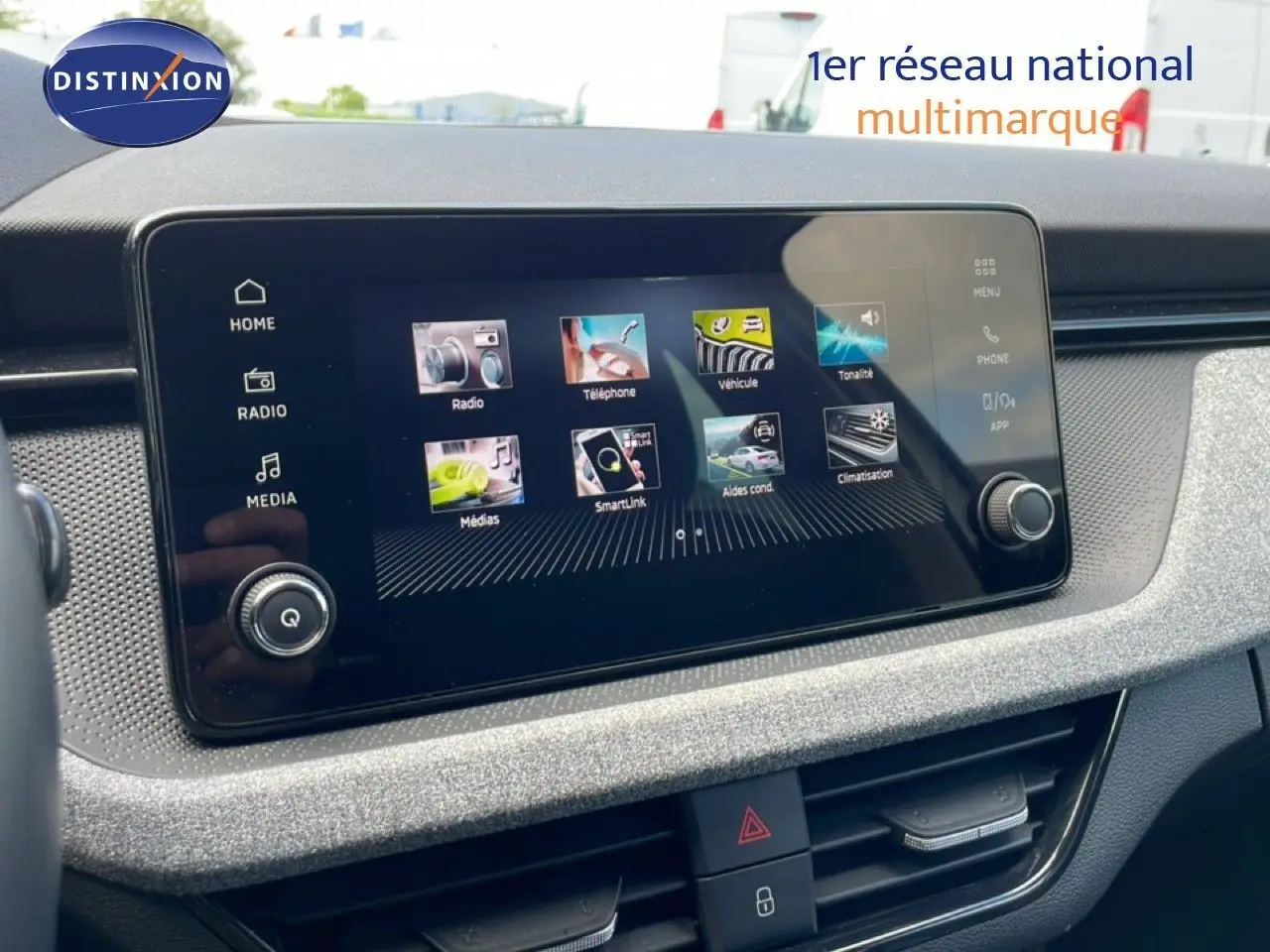 Écran tactile central du tableau de bord de la Skoda Scala blanc glacier, affichant les menus multimédias et connectivité.
