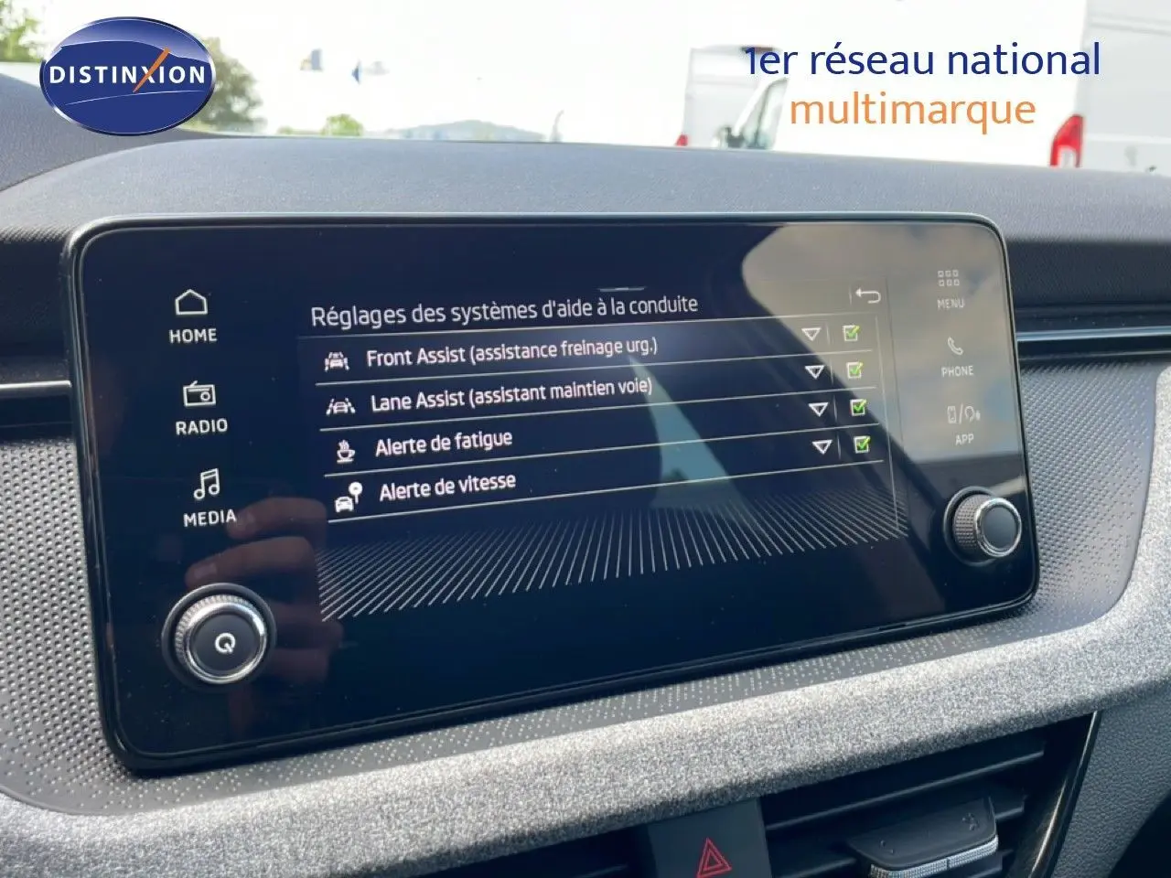 Écran tactile central du Skoda Scala 2025 affichant les réglages des aides à la conduite dans un intérieur gris noir.