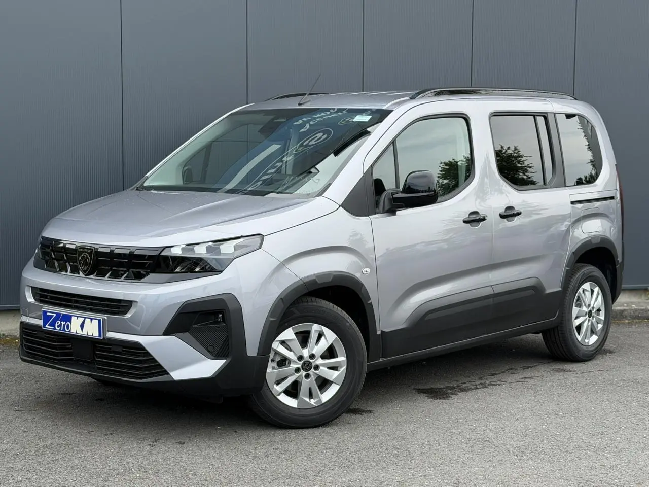 Peugeot Rifter gris acier en 3/4 avant droit, avec portes latérales coulissantes et jantes alu 16 pouces.