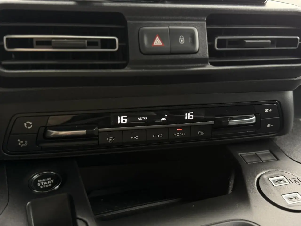 Gros plan sur la console centrale noire du Peugeot Rifter 2026, montrant la climatisation automatique bi-zone et le bouton start/stop.