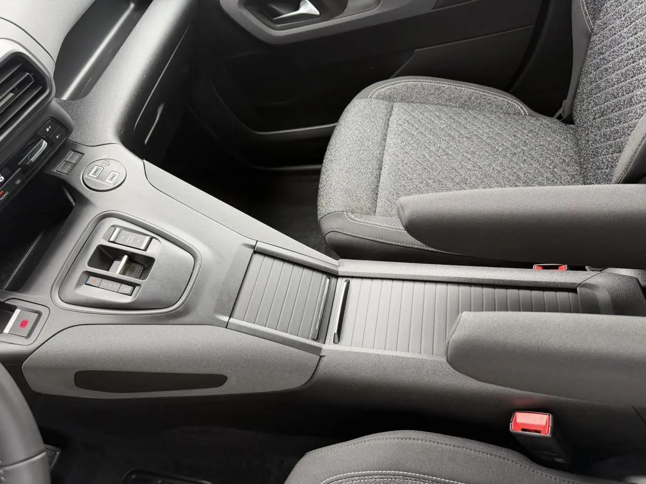 Vue intérieure centrée sur la console centrale et sièges avant gris du Peugeot Rifter M 1.5 BlueHDI 130 Allure 2026.