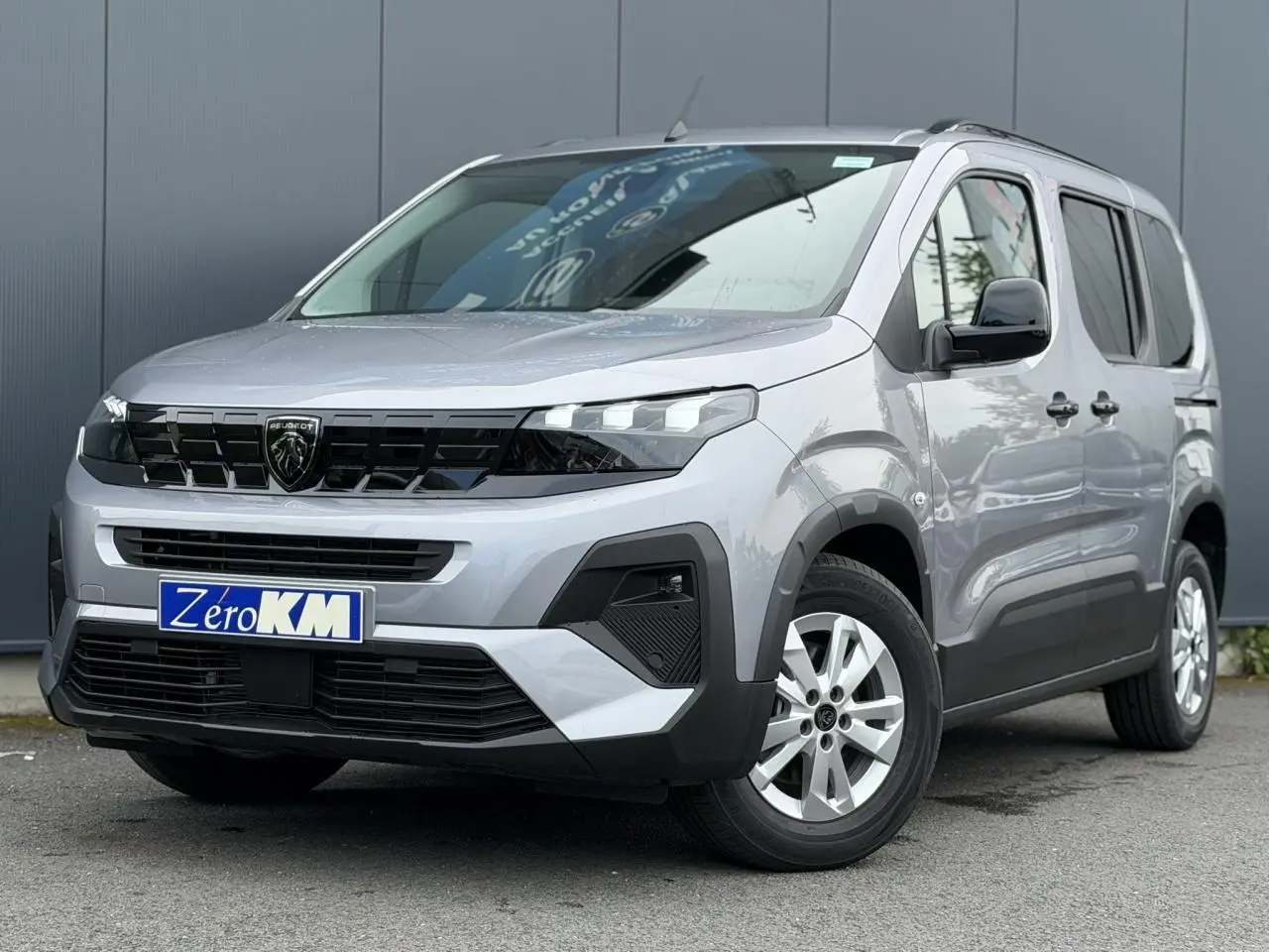 Peugeot Rifter gris acier vue 3/4 avant droit, avec calandre noire et jantes alu 16 pouces.