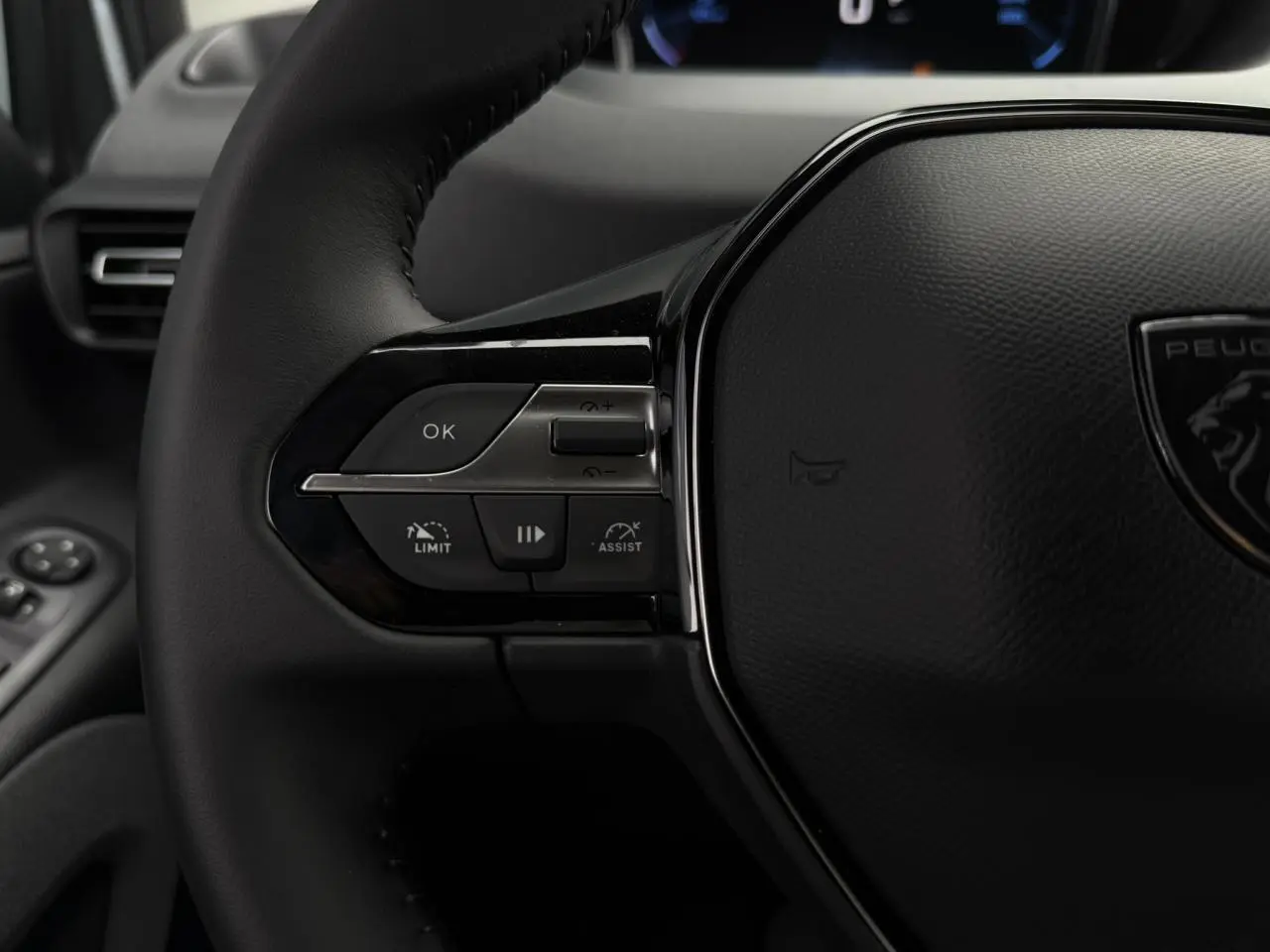 Gros plan sur le volant cuir multifonction du Peugeot Rifter 2026 avec commandes intégrées côté gauche.