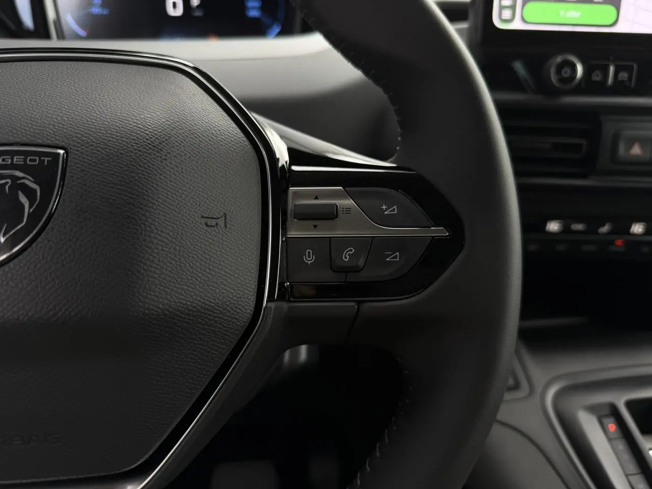 Gros plan sur le volant cuir multifonction du Peugeot Rifter 2026 avec commandes vocales et téléphone intégrées.