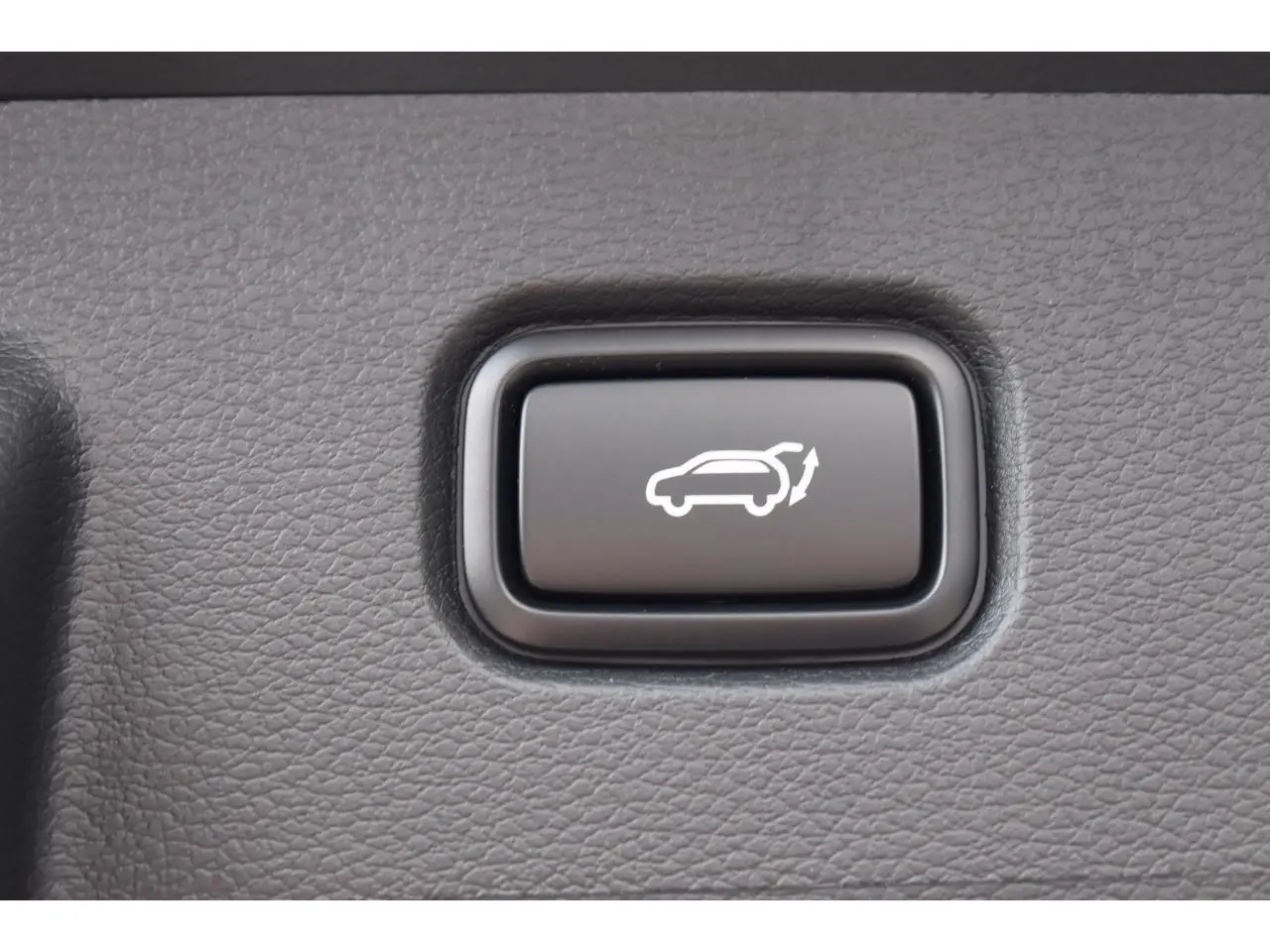 Bouton noir d'ouverture électrique du hayon sur le tableau de bord du Kia Sportage Hybride 239 ch GT-Line 2026.