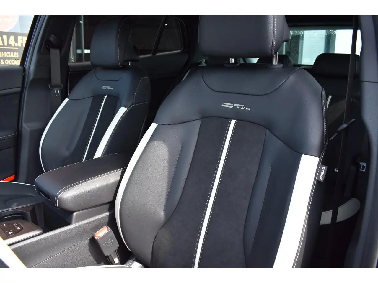 Gros plan sur les sièges avant bi-ton noir et gris du Kia Sportage GT-Line hybride 2026, avec logo GT-Line brodé.