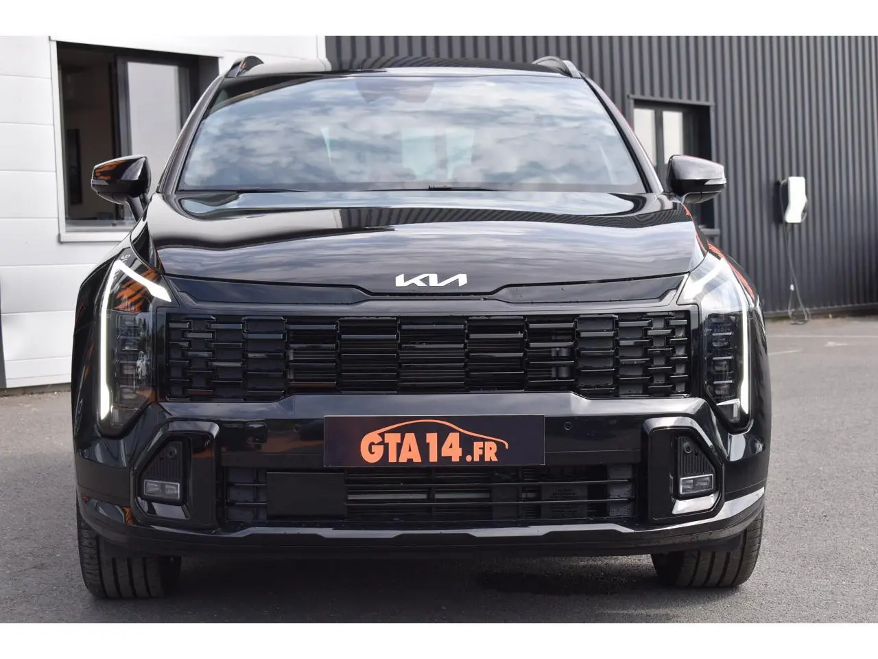 Vue frontale d'un KIA Sportage noir 2026 avec calandre noire et feux LED verticaux distinctifs.