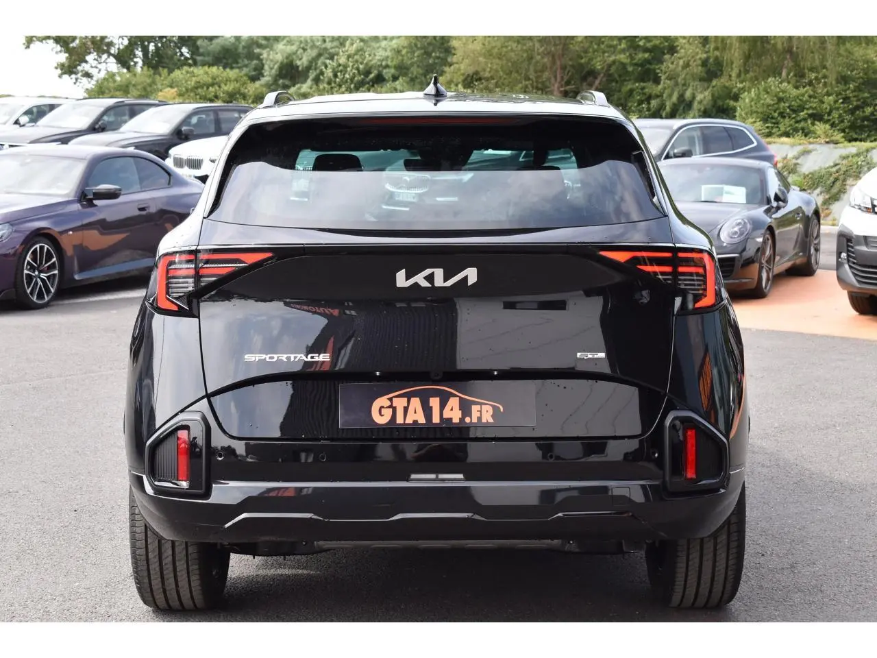 Vue arrière du KIA Sportage noir 2026 avec feux LED distinctifs et logo moderne sur le hayon.