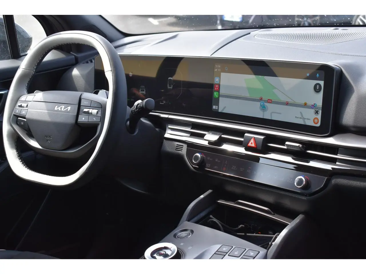 Vue intérieure du tableau de bord et volant noir du Kia Sportage hybride 2026 avec écran tactile large et commandes digitales.