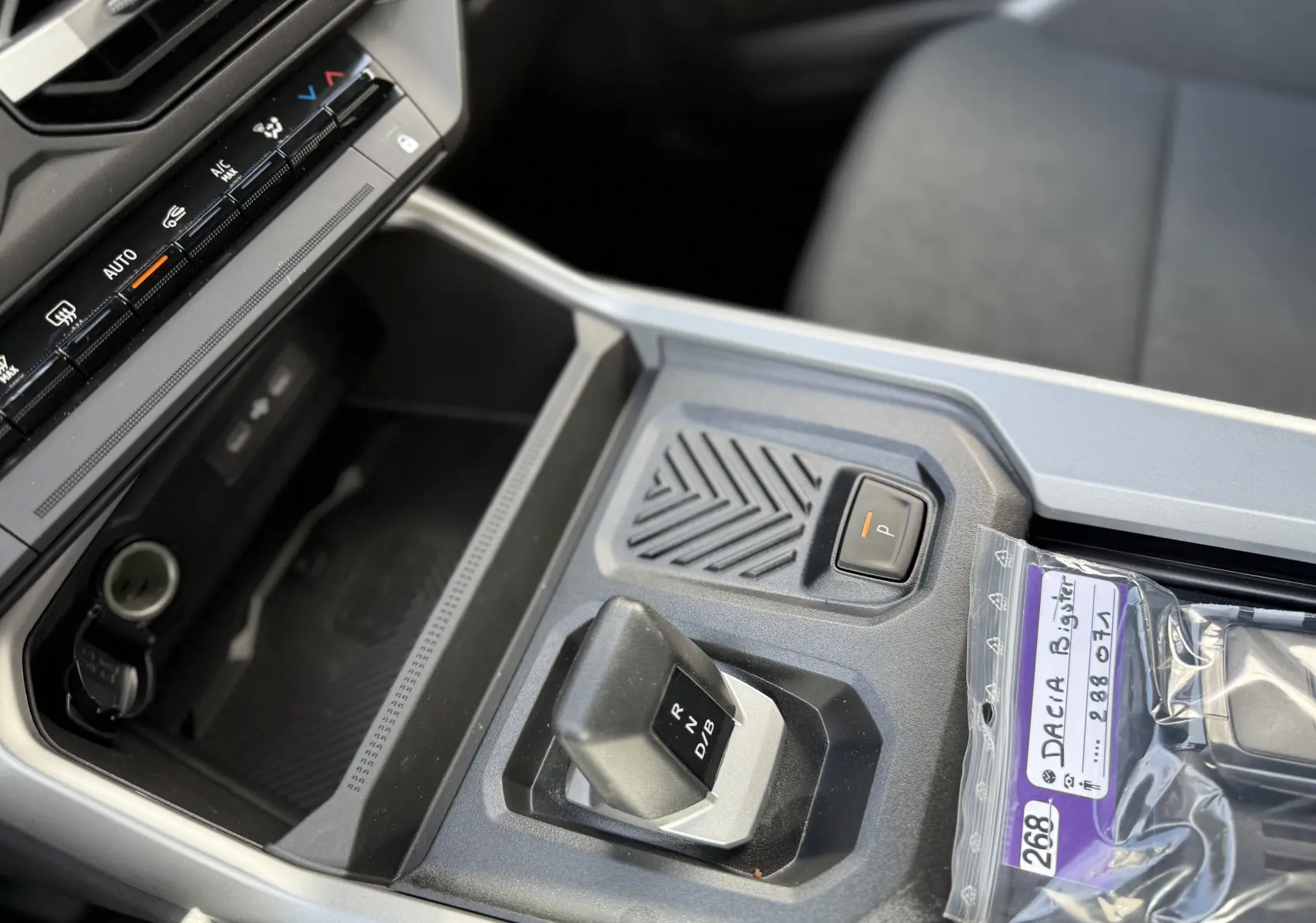 Gros plan sur la console centrale de la Dacia Bigster Hybrid 155 Journey 2026, avec levier de boîte auto et bouton de parking.