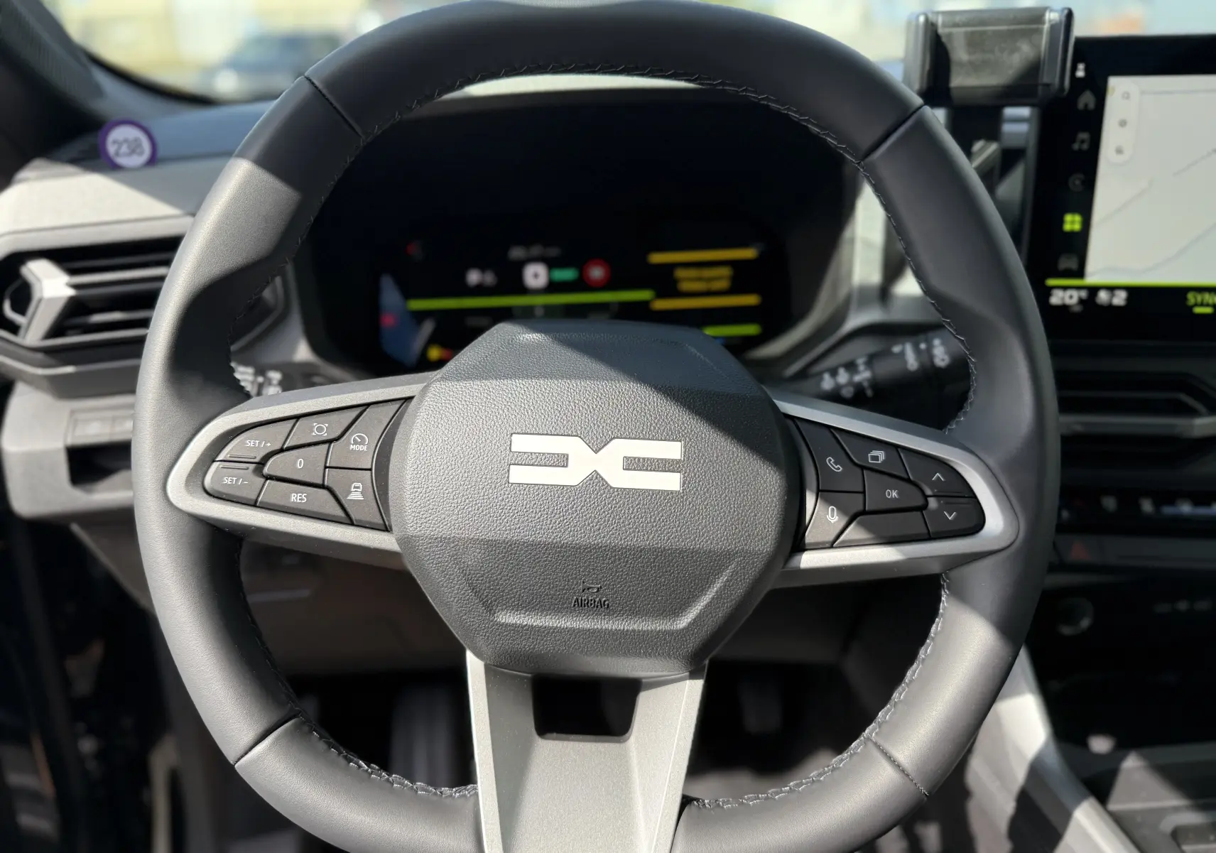 Vue rapprochée du volant noir du Dacia Bigster Hybrid 155 Journey 2026 avec commandes intégrées et tableau de bord numérique.