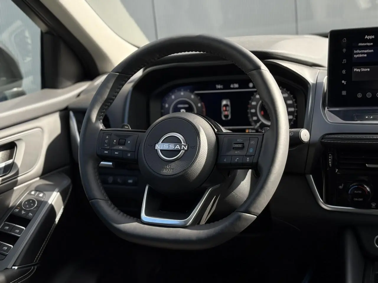 Volant cuir noir du Nissan Qashqai 2025, vue frontale du poste de conduite avec tableau de bord numérique.