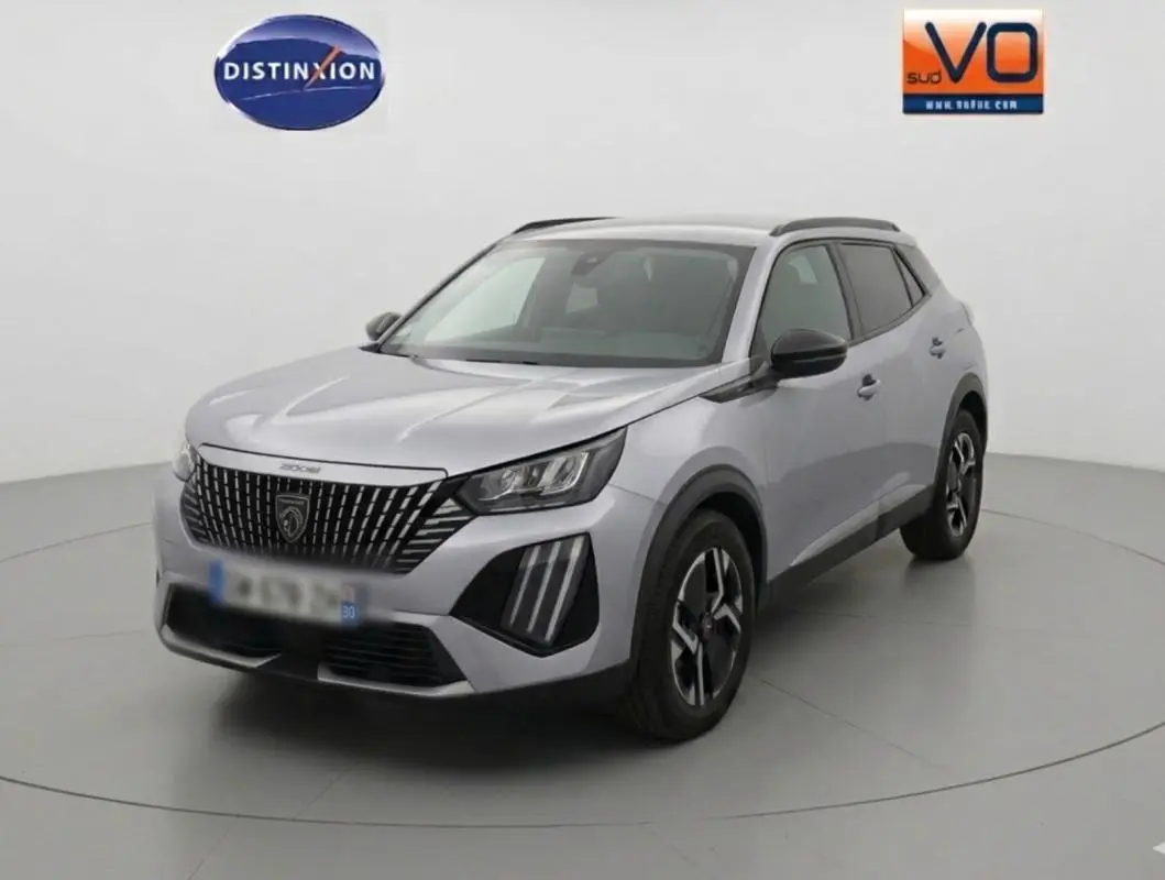 Peugeot 2008 Hybrid gris en 3/4 avant droit avec barres de toit et jantes alliage 17 pouces visibles.