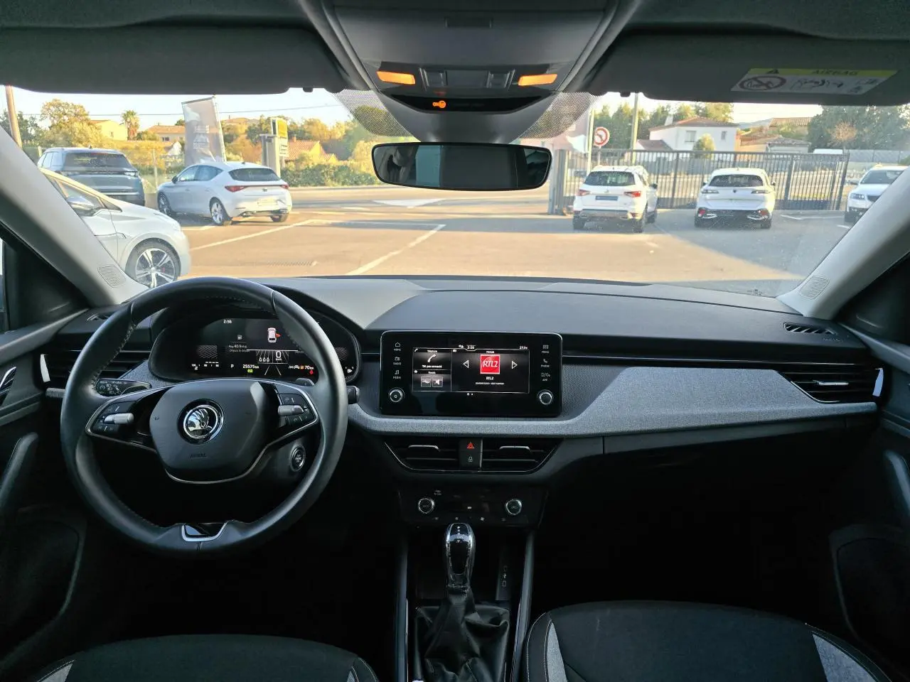Vue intérieure avant du tableau de bord de la Skoda Scala 2024 gris graphite avec écran tactile et volant multifonctions.