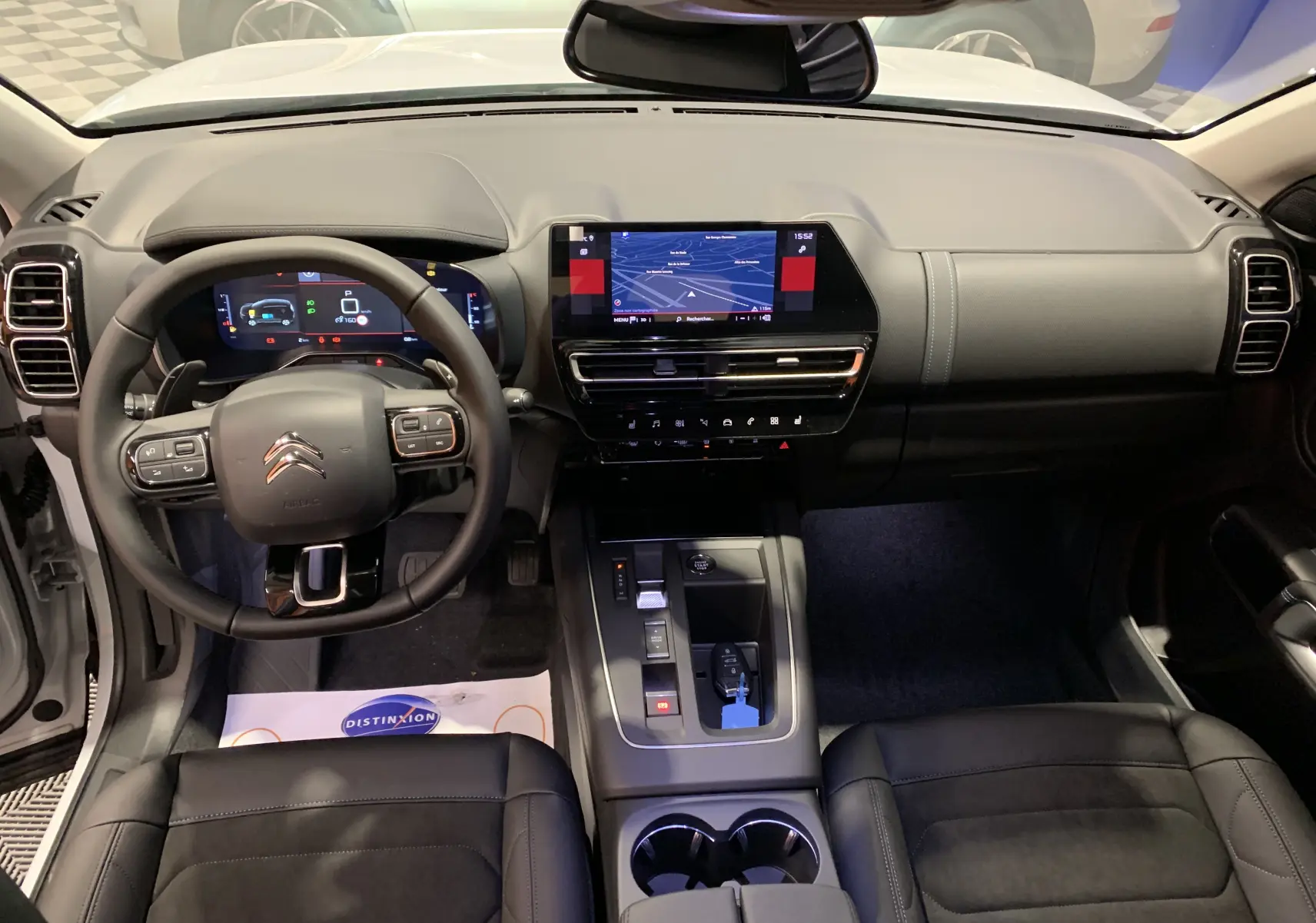 Gros plan sur les commandes de lève-vitres et réglage des rétroviseurs côté conducteur du Citroën C5 Aircross hybride blanc 2024.