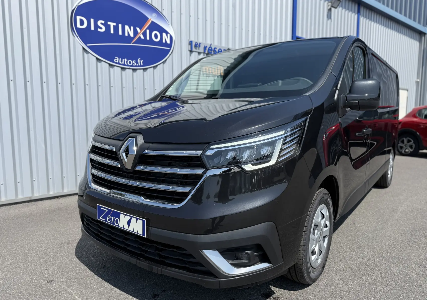 Renault Trafic Fourgon noir crépuscule métal vu en 3/4 avant droit, avec calandre chromée et phares LED distinctifs.