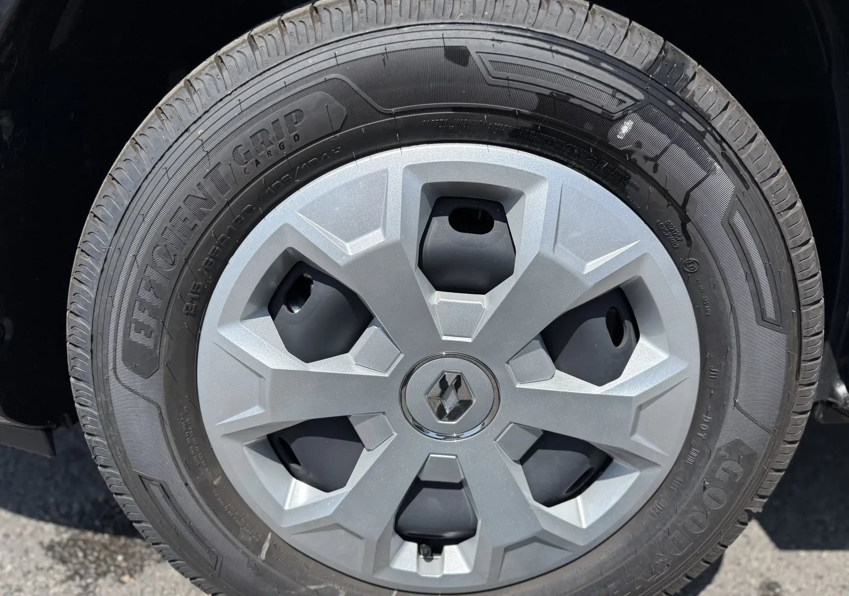 Gros plan sur la roue avant gauche du Renault Trafic Fourgon noir crépuscule avec jante et logo Renault central.