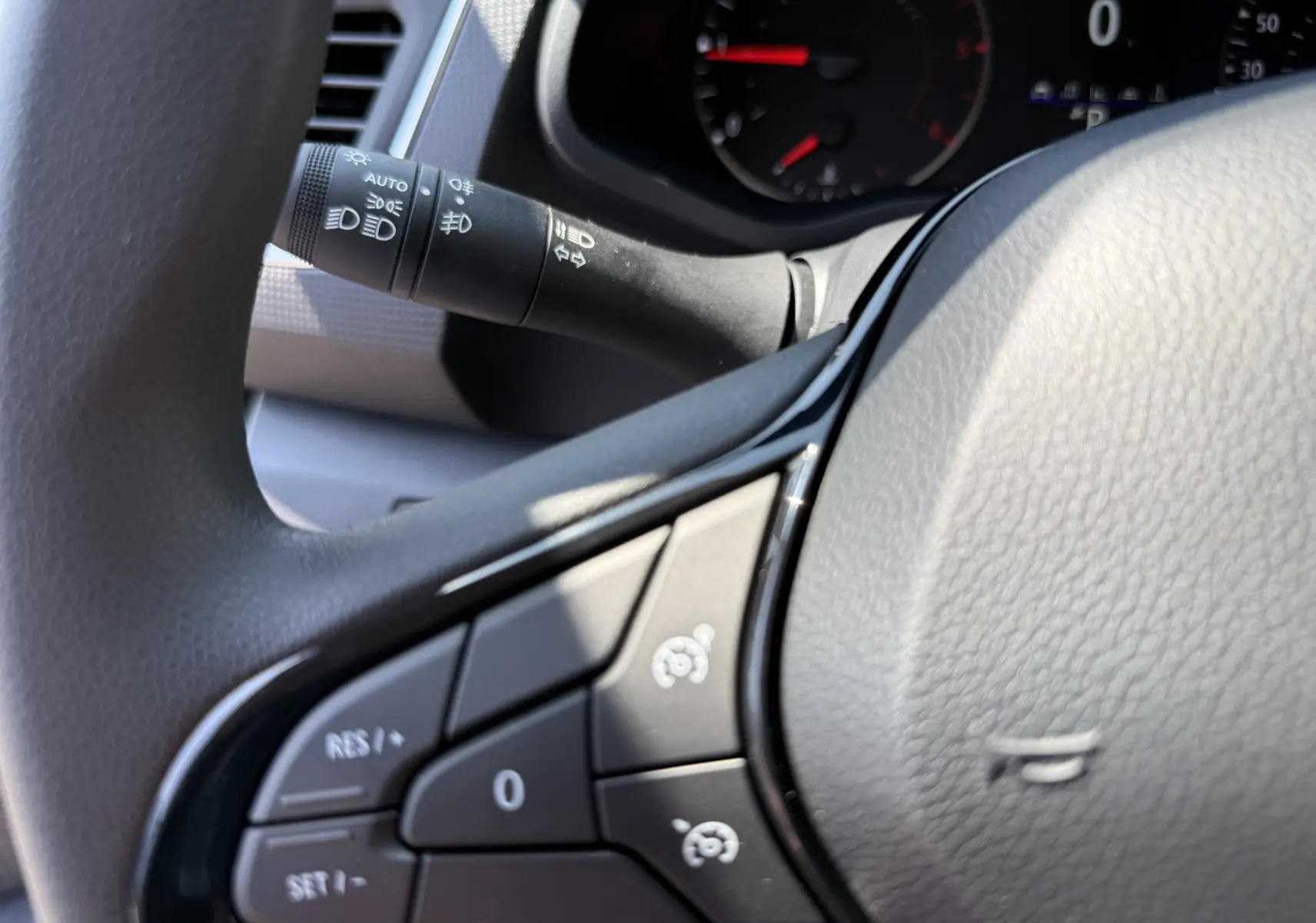 Gros plan sur les commandes au volant du Renault Trafic Fourgon noir crépuscule, avec tableau de bord en arrière-plan.