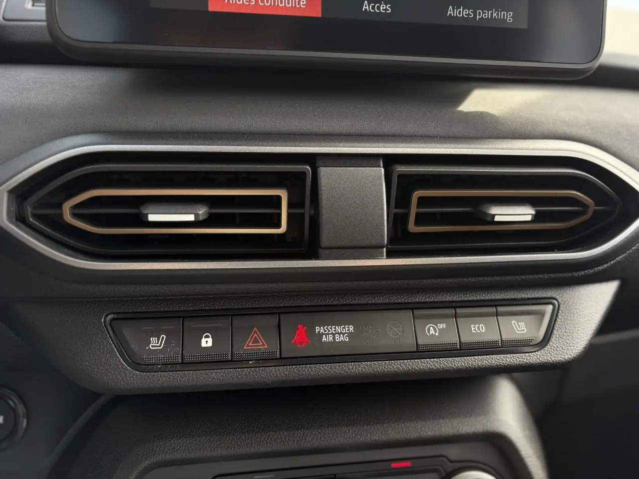 Détail des aérateurs et des commandes centrales du tableau de bord du Dacia Jogger Gris Schiste 2024.