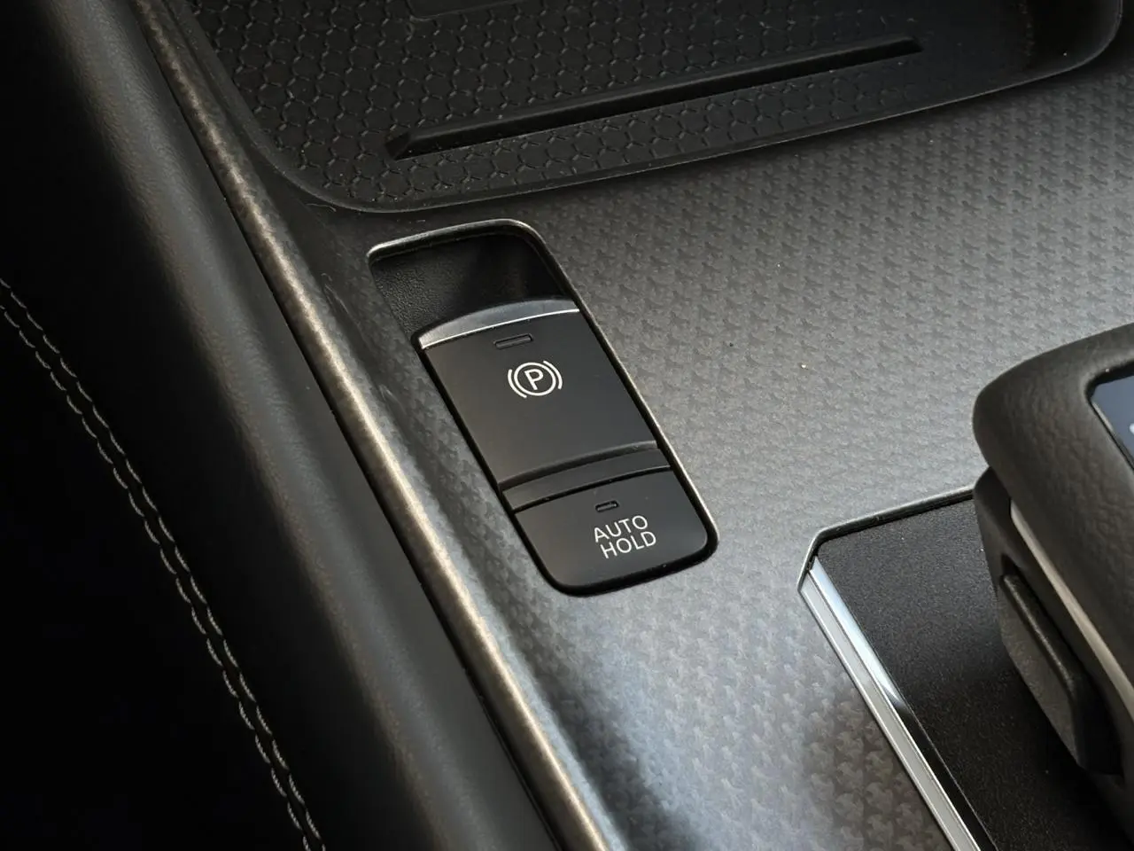 Gros plan sur la commande de frein à main électrique et fonction Auto Hold dans l’habitacle du Nissan Qashqai gris Ceramic 2025
