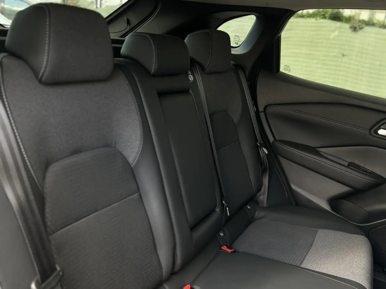 Banquette arrière en sellerie mixte noire du Nissan Qashqai 2025, vue côté droit avec appuie-têtes et ceinture de sécurité.