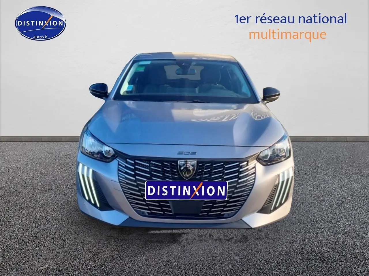 Vue avant d'une Peugeot 208 1.2 100 Allure gris Artense avec phares LED et calandre distinctive.