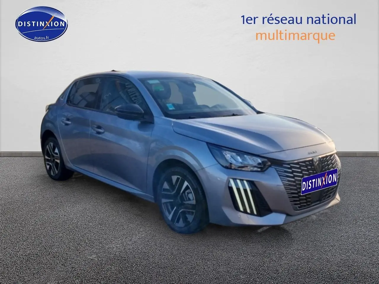 Peugeot 208 gris artense vue 3/4 avant droit, mettant en valeur la calandre et les feux LED verticaux.