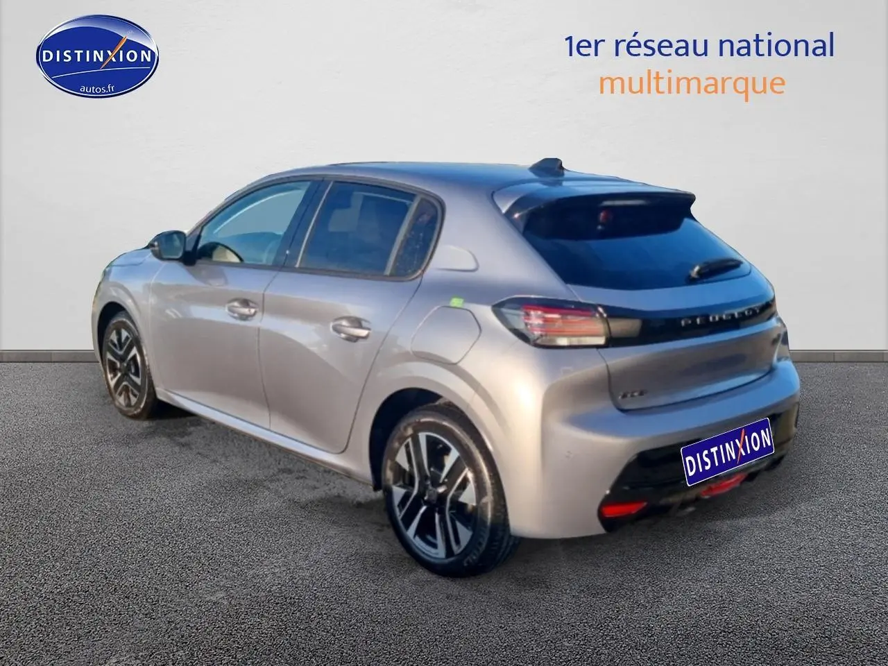 Vue 3/4 arrière droite d'une Peugeot 208 1.2 100 Allure gris Artense avec jantes alu et vitres teintées.