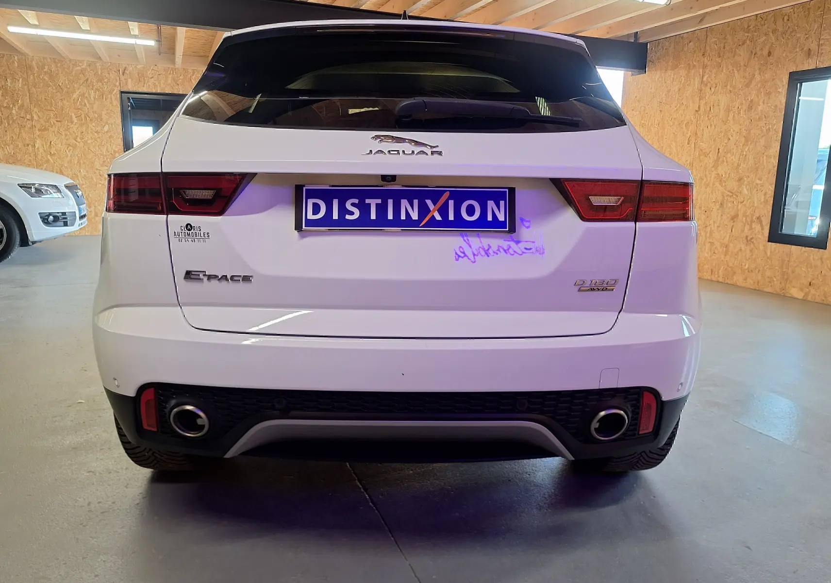 Vue arrière d'un Jaguar E-PACE blanc 2019 avec double sortie d'échappement et feux arrière LED en intérieur.