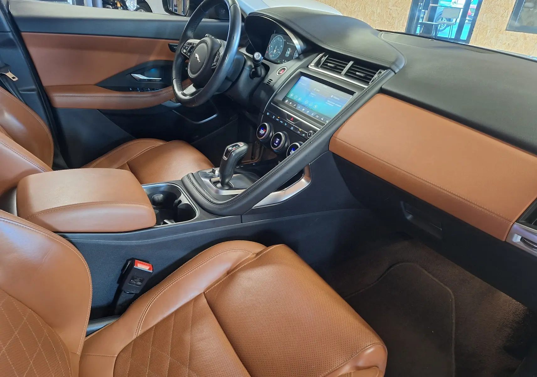 Intérieur Jaguar E-PACE 2.0 D180 R-DYNAMIC HSE 2019, vue côté conducteur, sièges cuir marron et tableau de bord noir.