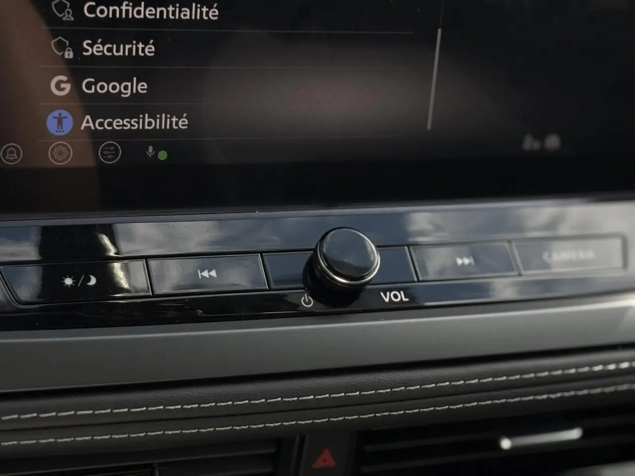 Gros plan sur la molette de volume et les commandes multimédia du tableau de bord du Nissan Qashqai gris Ceramic 2025