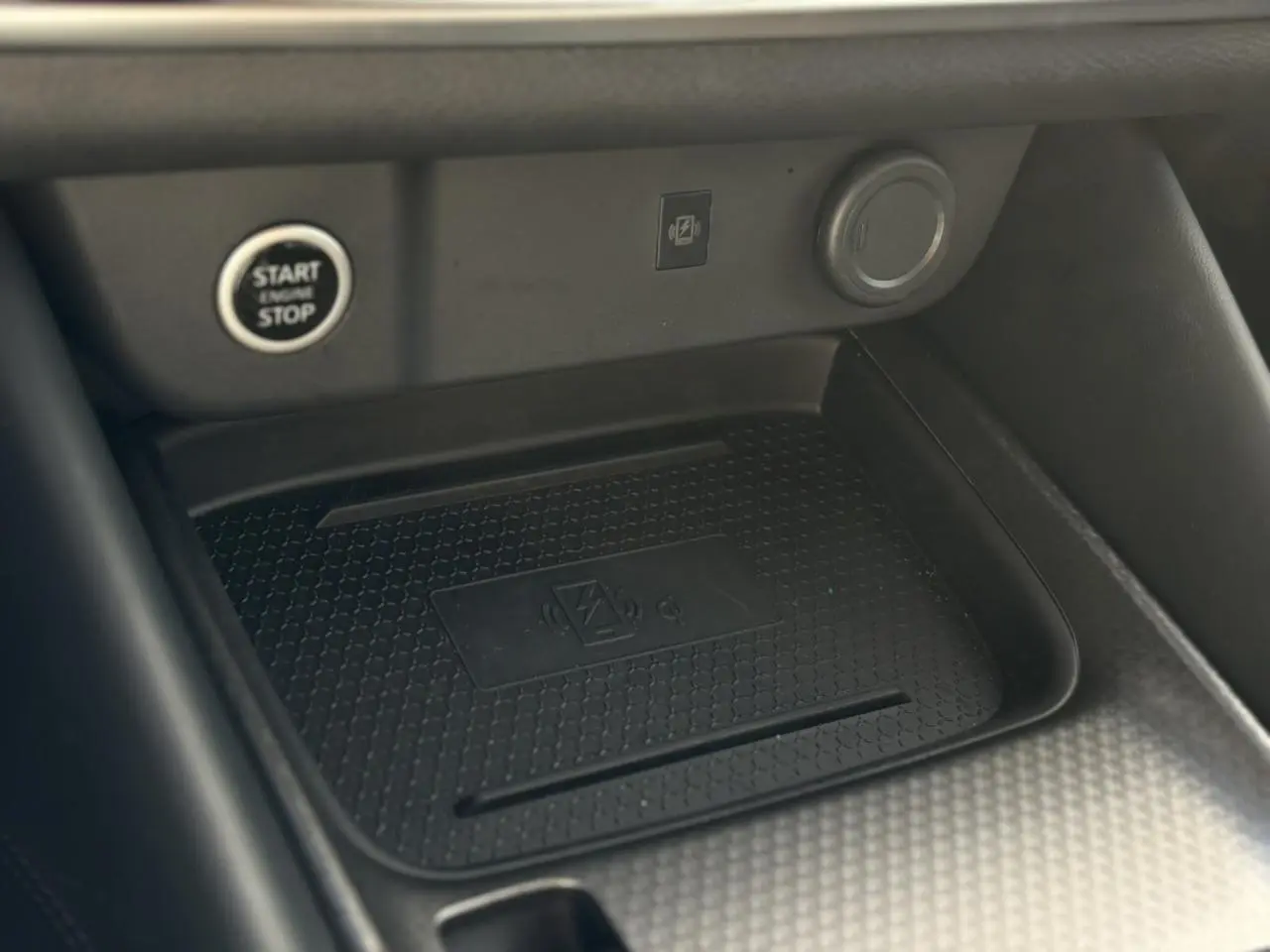 Détail du chargeur à induction et bouton Start/Stop dans l'habitacle du Nissan Qashqai III gris Ceramic 2025.