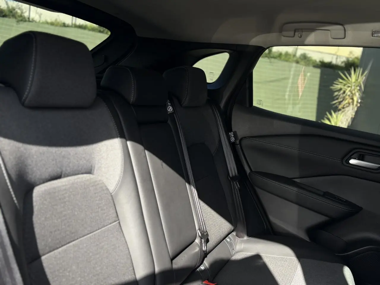 Vue du siège arrière côté droit du Nissan Qashqai gris Ceramic 2025 avec sellerie mixte tissu et TEP noire.