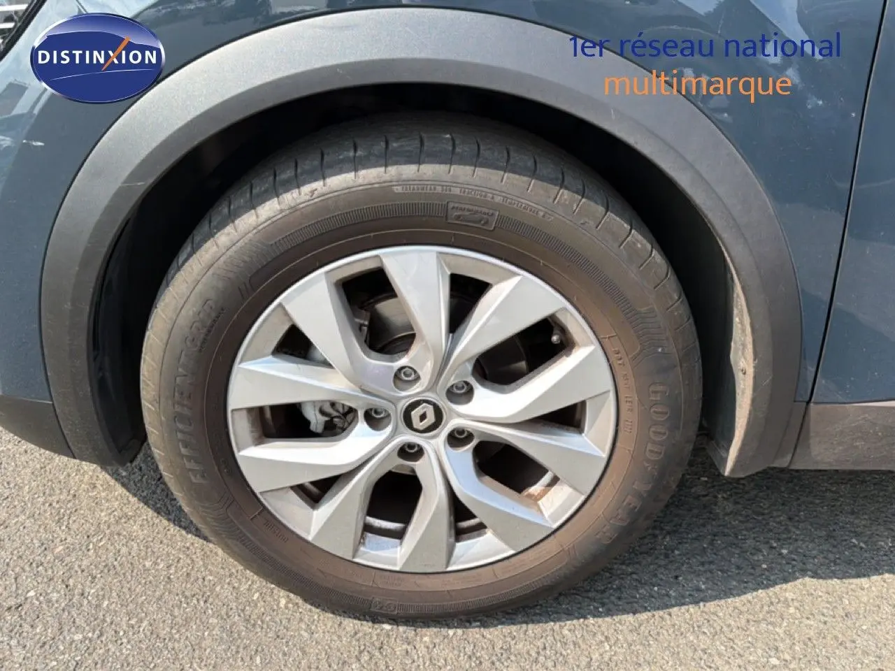 Gros plan sur la roue avant gauche d’un Renault Captur bleu marine fumé avec jante alliage à plusieurs branches.