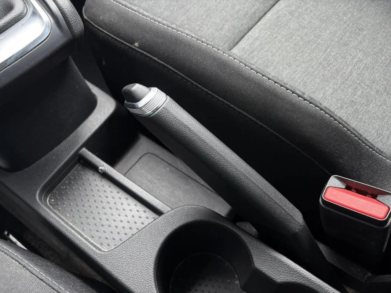 Gros plan sur le frein à main manuel et la console centrale noire du Renault Captur TCE 90 Business 2022.