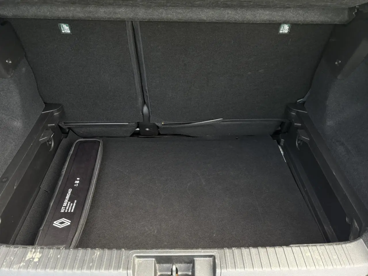 Coffre ouvert du Renault Captur blanc nacré 2022, vue intérieure montrant un rangement sécurisé et tapis noir.