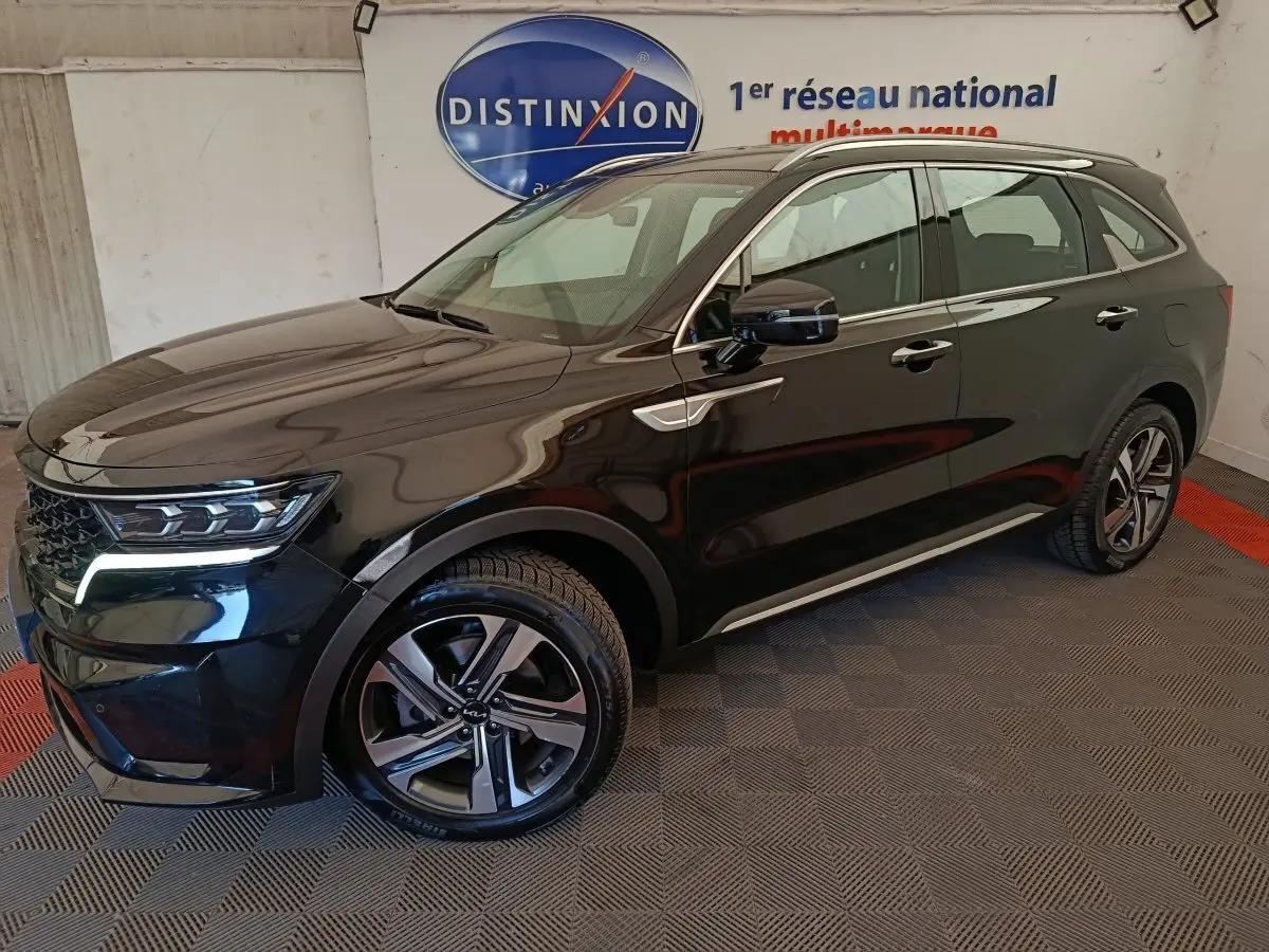 KIA Sorento noir hybride rechargeable vu en 3/4 avant droit, avec jantes alliage et feux LED allumés.