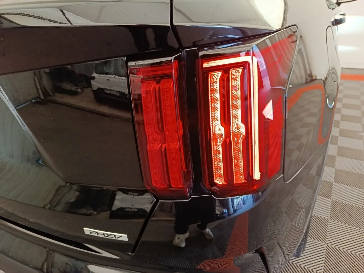 Gros plan sur le feu arrière droit rouge du KIA Sorento noir hybride rechargeable avec badge PHEV visible.