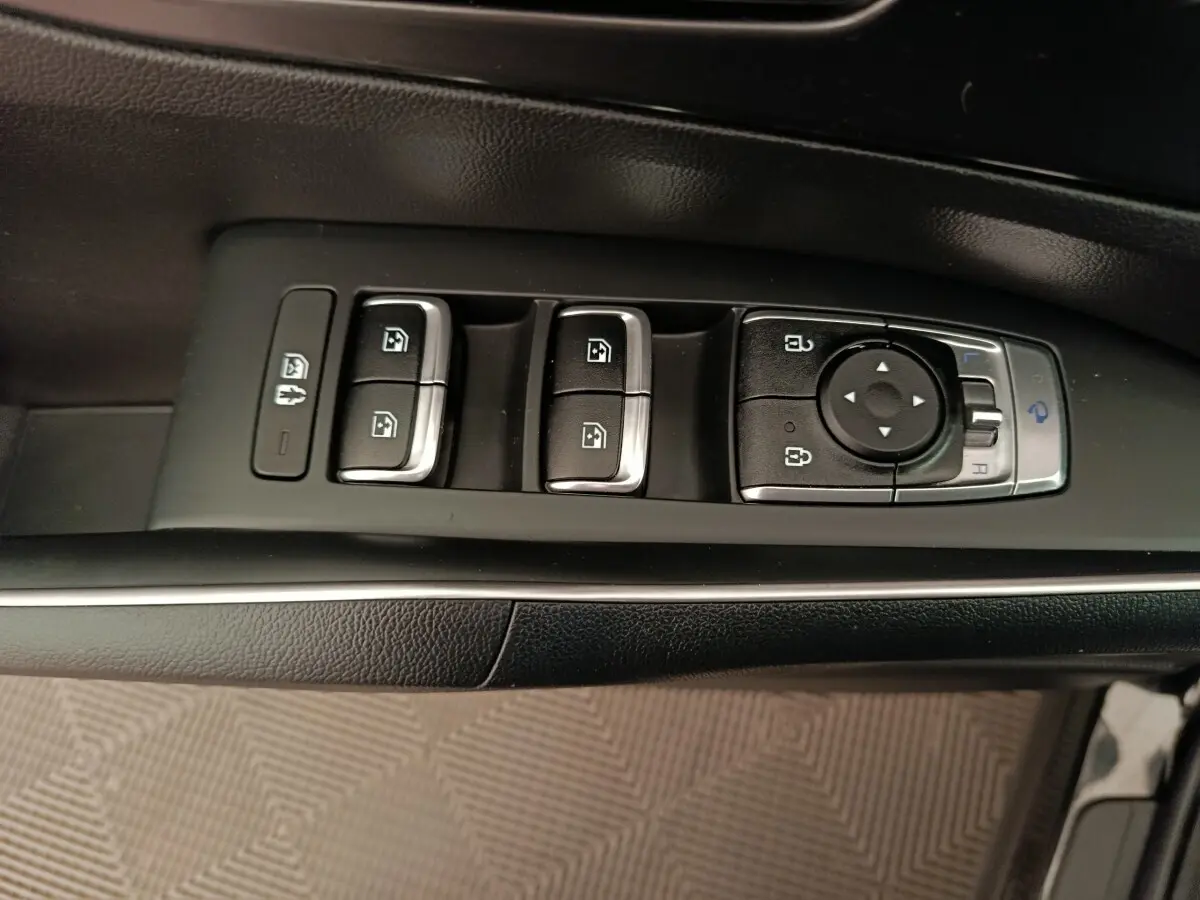Gros plan sur les commandes de lève-vitres et rétroviseurs côté conducteur du Kia Sorento noir 2023.