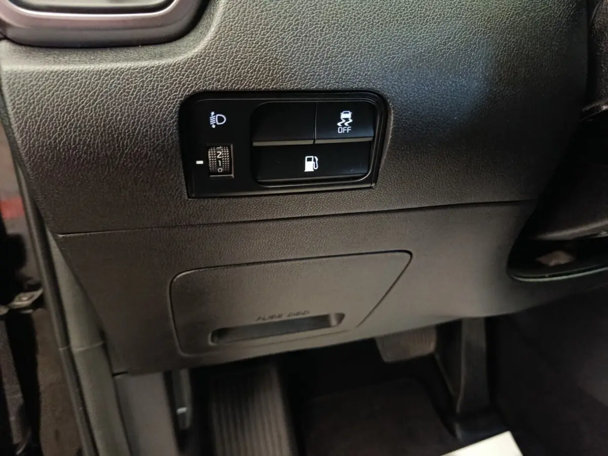 Gros plan sur les commandes noires du tableau de bord côté gauche du Kia Sorento noir 2023 hybride rechargeable.