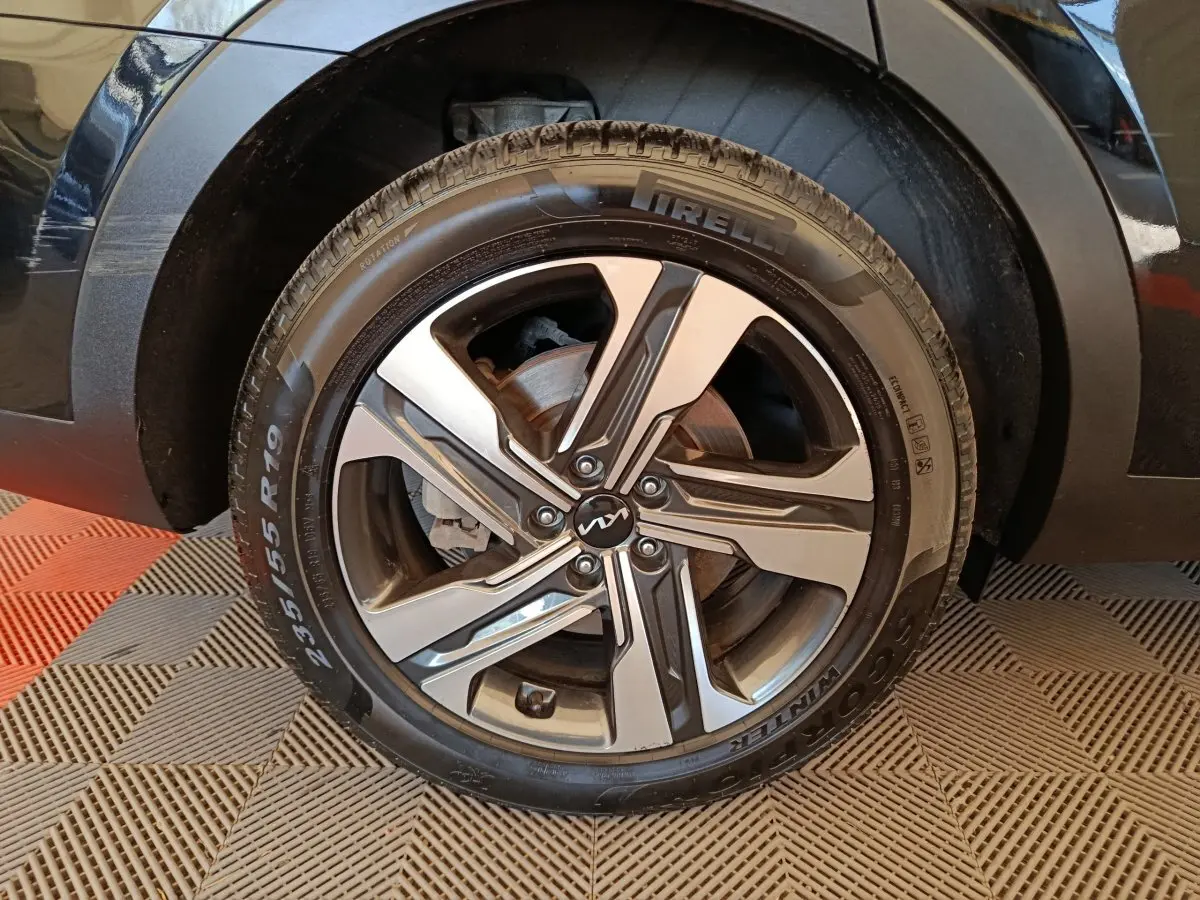 Gros plan sur la roue avant droite noire du Kia Sorento 2023 avec jante alliage bicolore et pneu Pirelli.