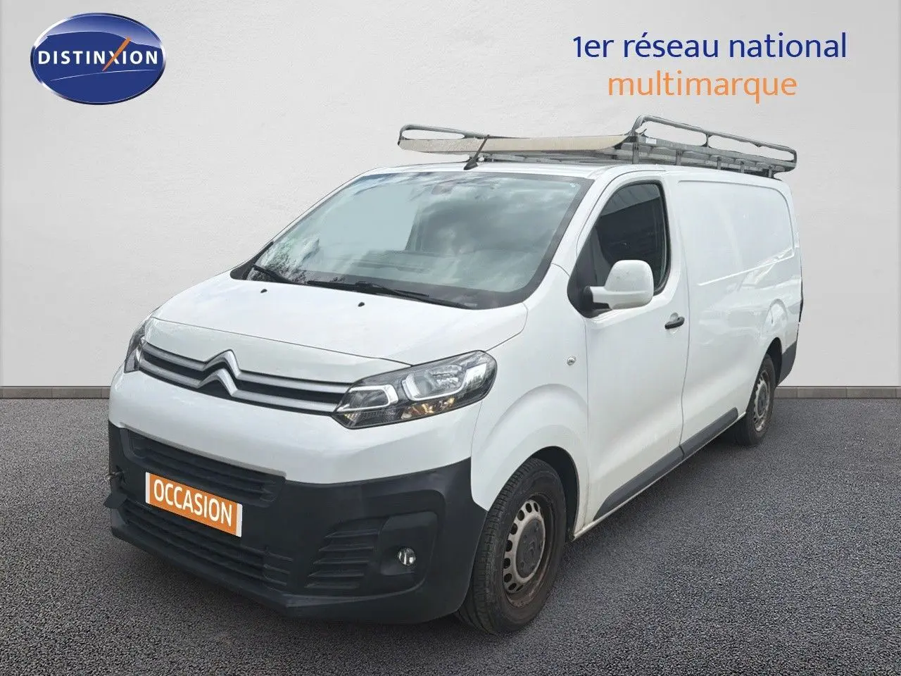 Vue 3/4 avant droit d’un utilitaire Citroën Jumpy XL blanc avec galerie de toit et pare-chocs noir.