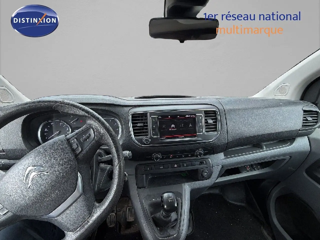 Vue intérieure du tableau de bord et volant côté gauche du Citroën Jumpy blanc, avec console centrale et écran tactile.