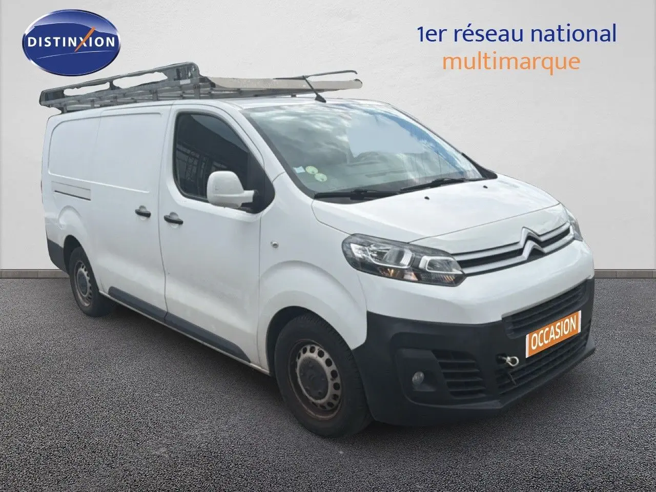 Citroën Jumpy XL blanc en 3/4 avant droit avec galerie de toit et pare-chocs noirs visibles.