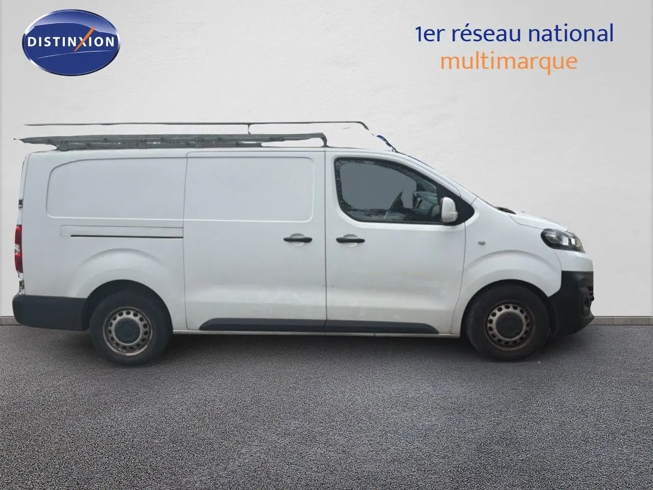 Vue latérale droite d’un utilitaire Citroën Jumpy XL blanc de 2017 avec galerie de toit et jantes acier.